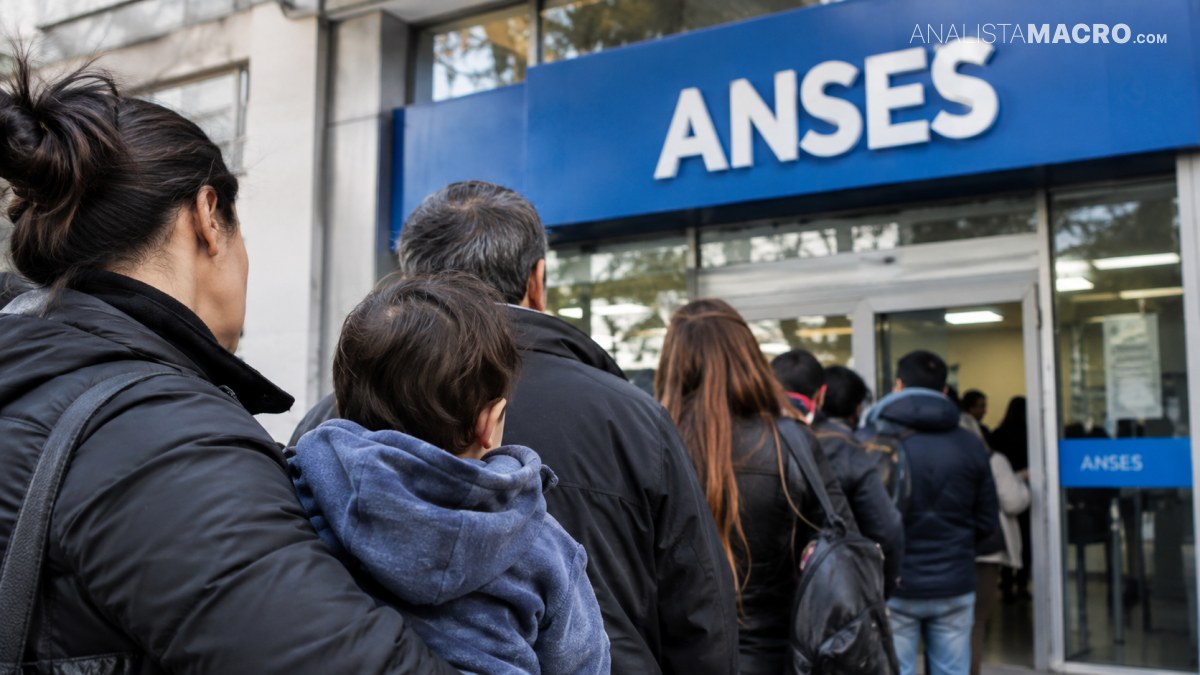 Personas hacen fila frente a la entrada de una oficina con un letrero azul que dice “ANSES”.