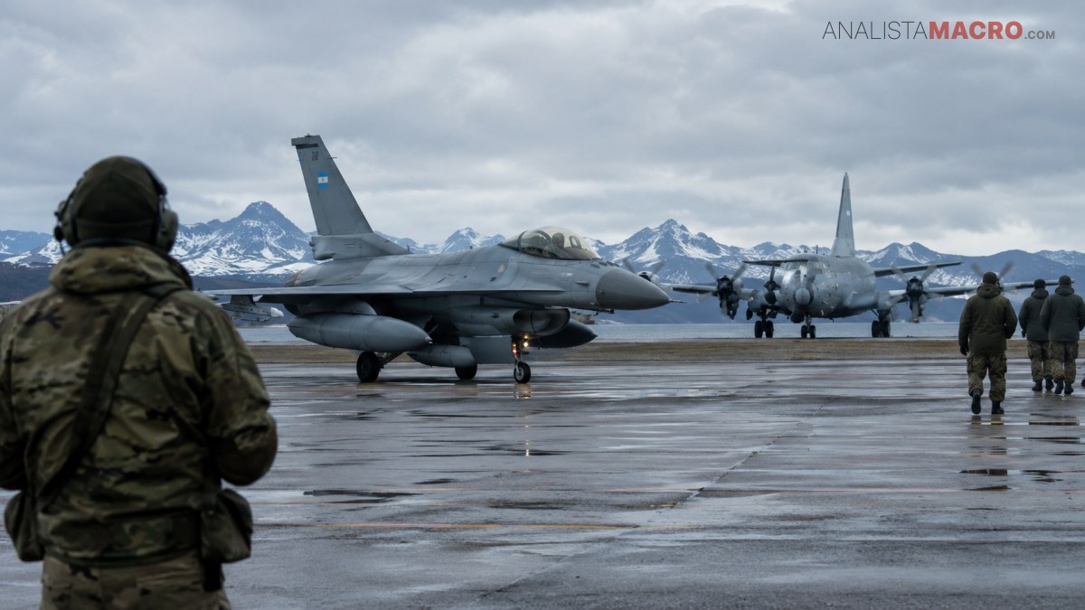 Avión de combate en una pista mojada, con personal militar y montañas nevadas bajo un cielo nublado.
