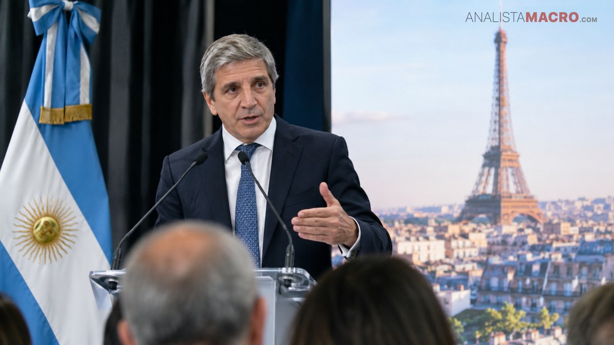 Un hombre de traje habla ante un atril, con una bandera argentina y una imagen de la Torre Eiffel al fondo.