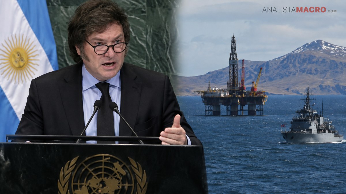 Hombre con gafas habla ante un atril, mientras detrás se ven una bandera, una plataforma petrolera, un buque y montañas nevadas.