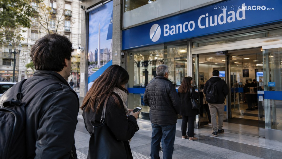 Personas hacen fila frente a la entrada acristalada de una sucursal del Banco Ciudad, mientras otras caminan por la vereda.