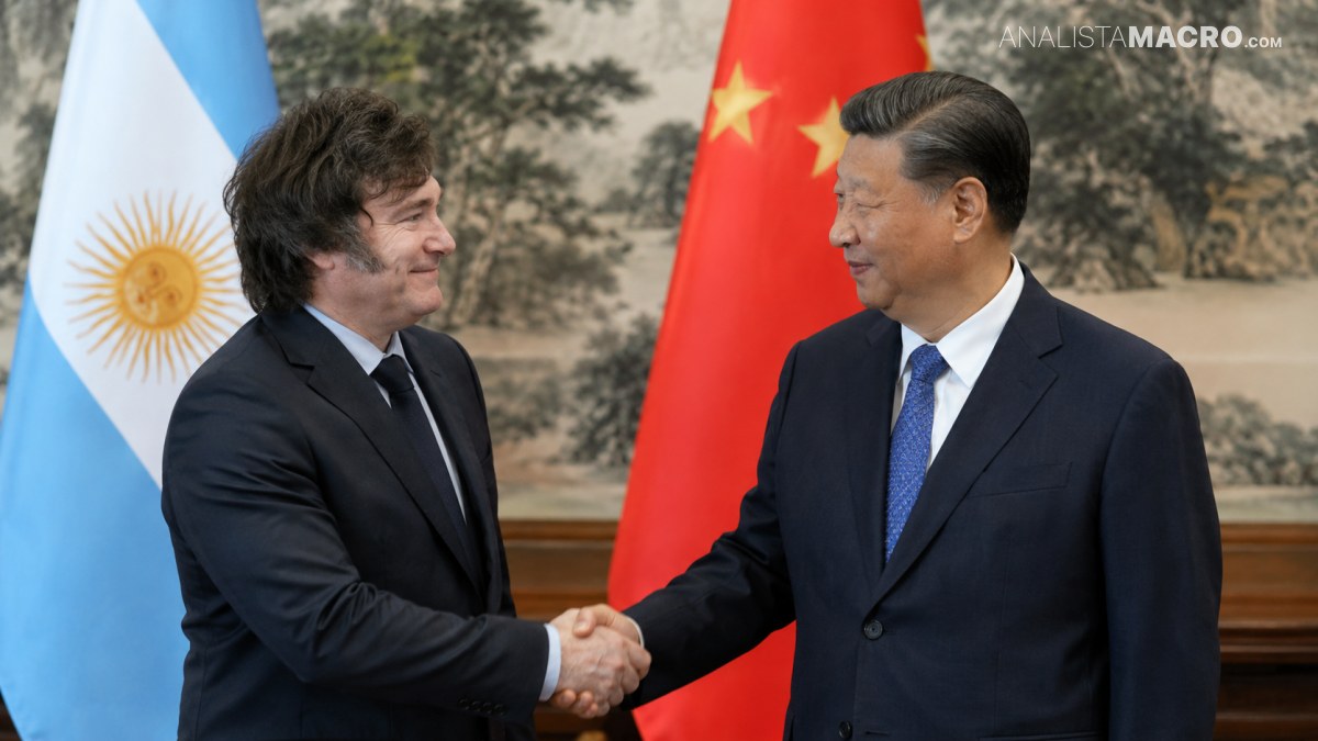 Dos hombres con traje estrechan sus manos frente a las banderas de Argentina y China.