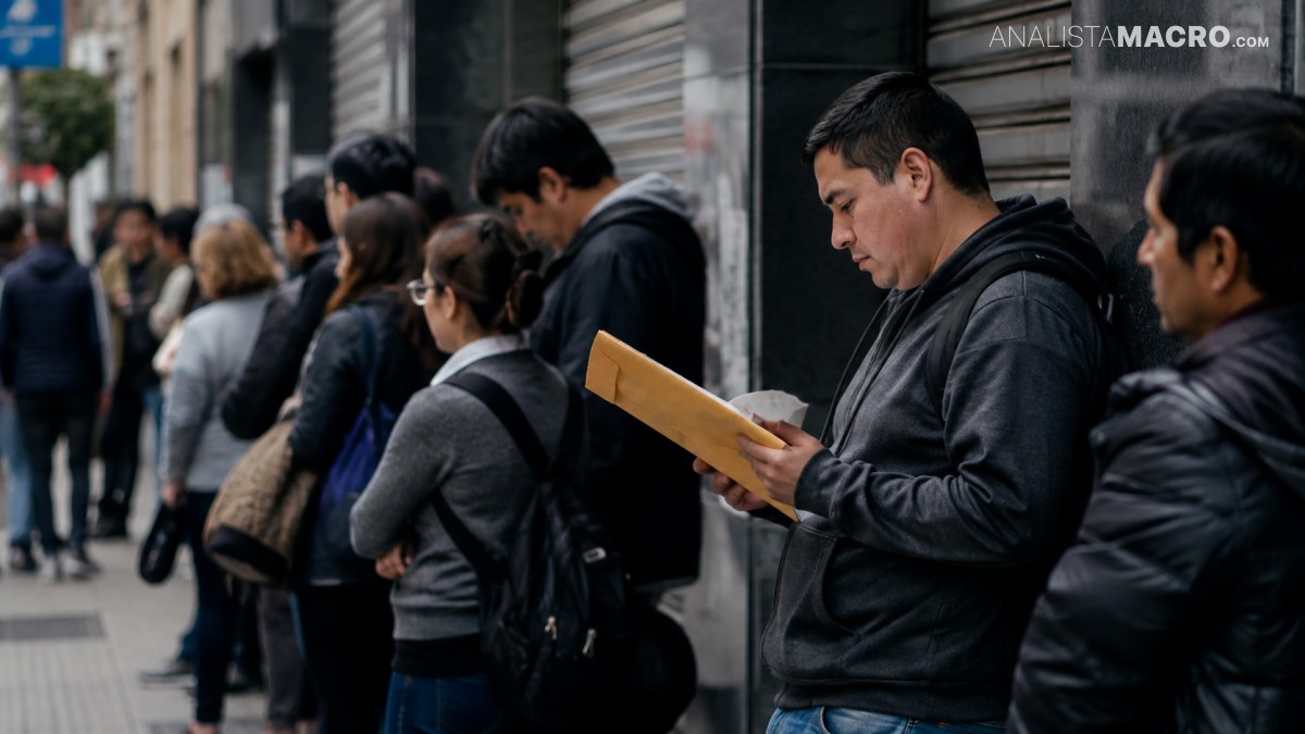 Un hombre con sudadera sostiene un cuaderno mientras camina entre personas en la calle urbana.