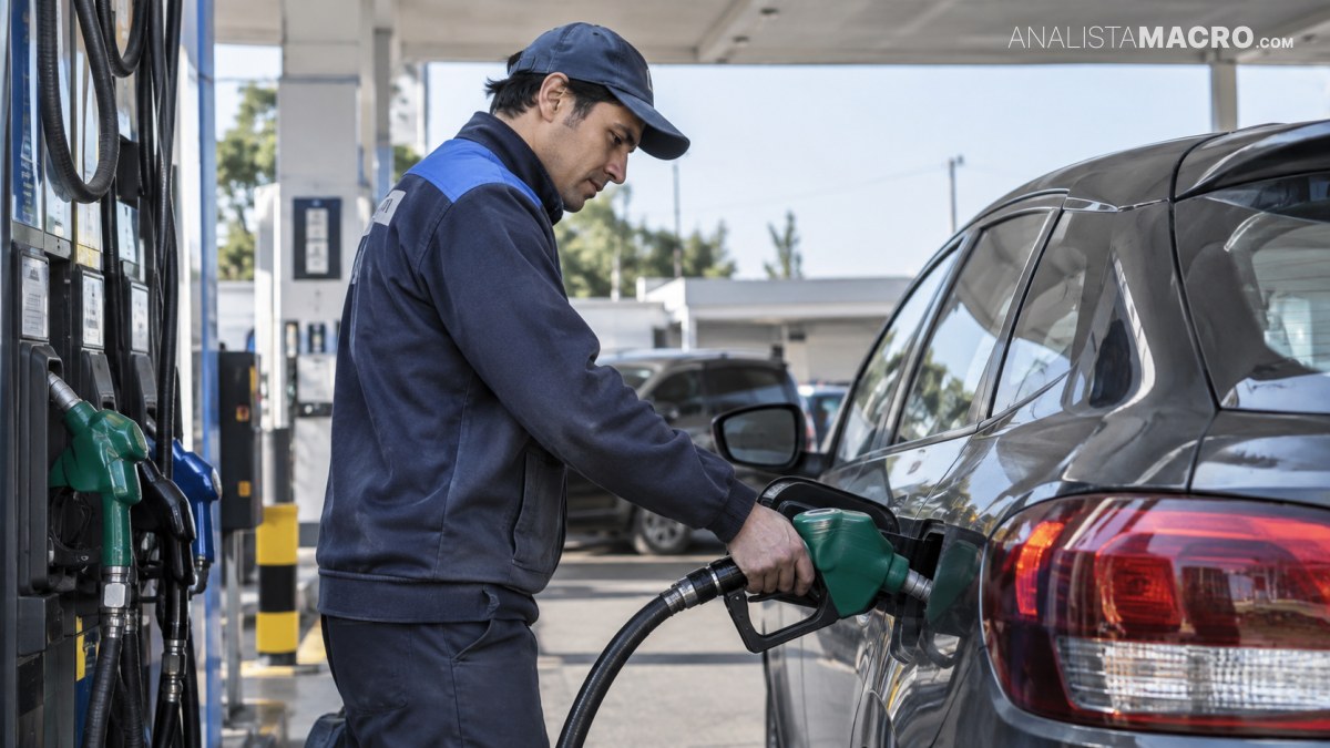 Un trabajador con uniforme azul reposta combustible en un automóvil oscuro junto a un surtidor de una estación de servicio.