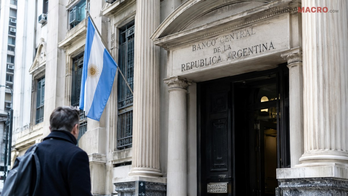 Persona frente a la entrada del Banco Central de la República Argentina, junto a una bandera argentina.