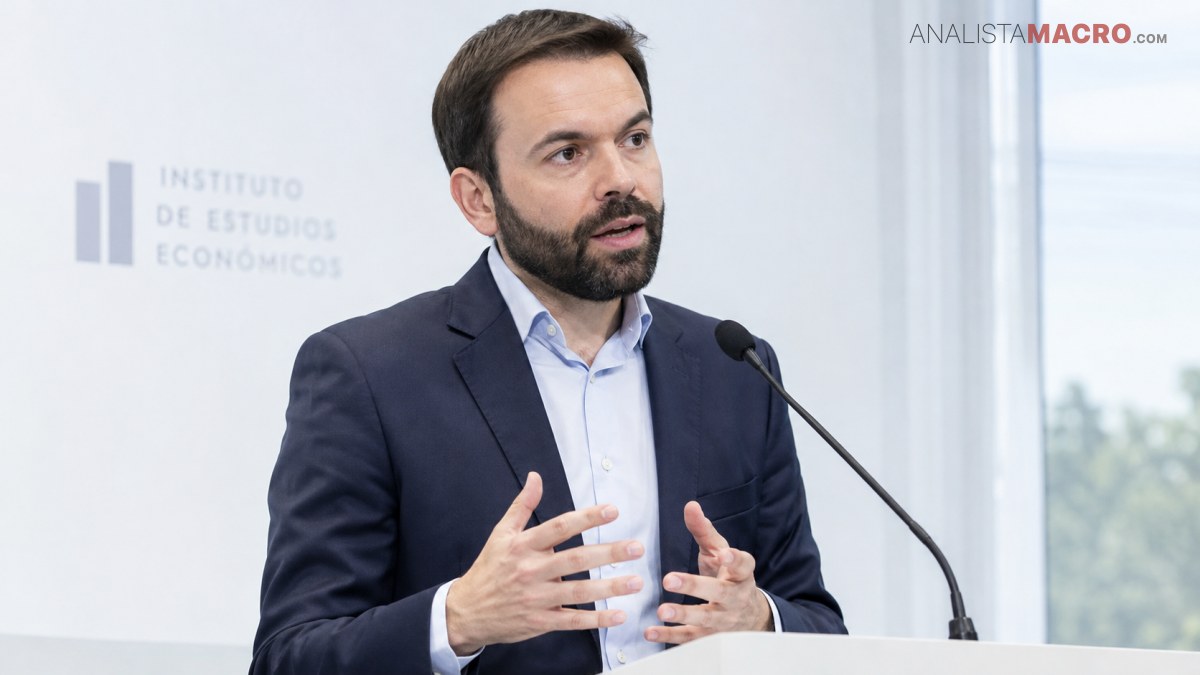 Hombre con barba, traje oscuro y camisa clara habla ante un micrófono, gesticulando con ambas manos.
