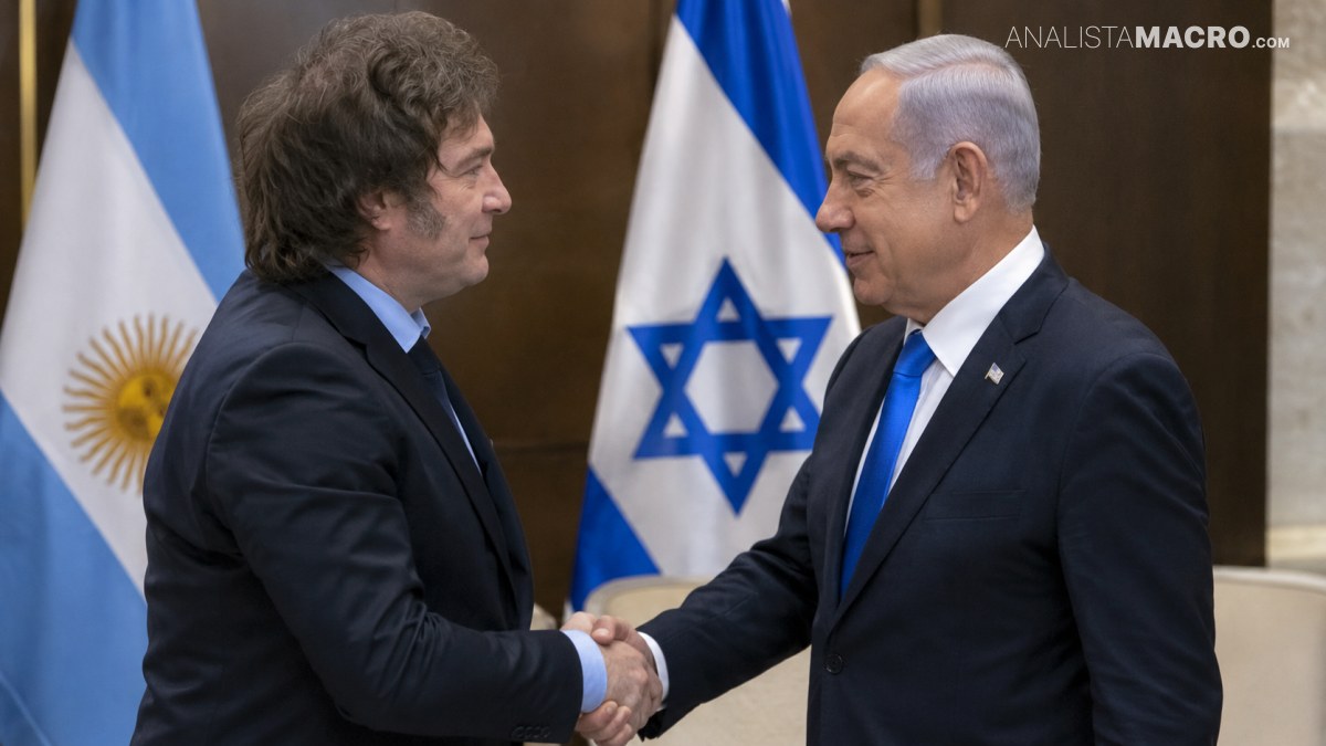 Dos hombres con trajes se dan la mano frente a banderas argentina e israelí.