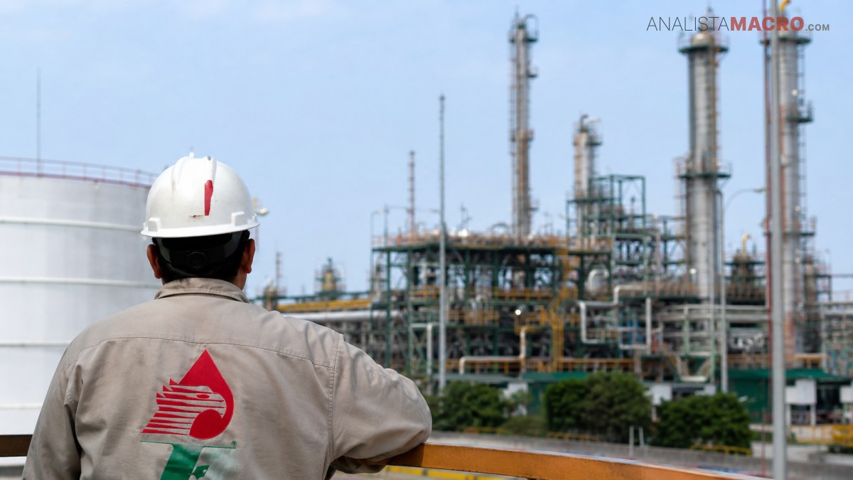 Trabajador con casco blanco observa una planta industrial con tuberías, estructuras metálicas y altas torres al fondo.